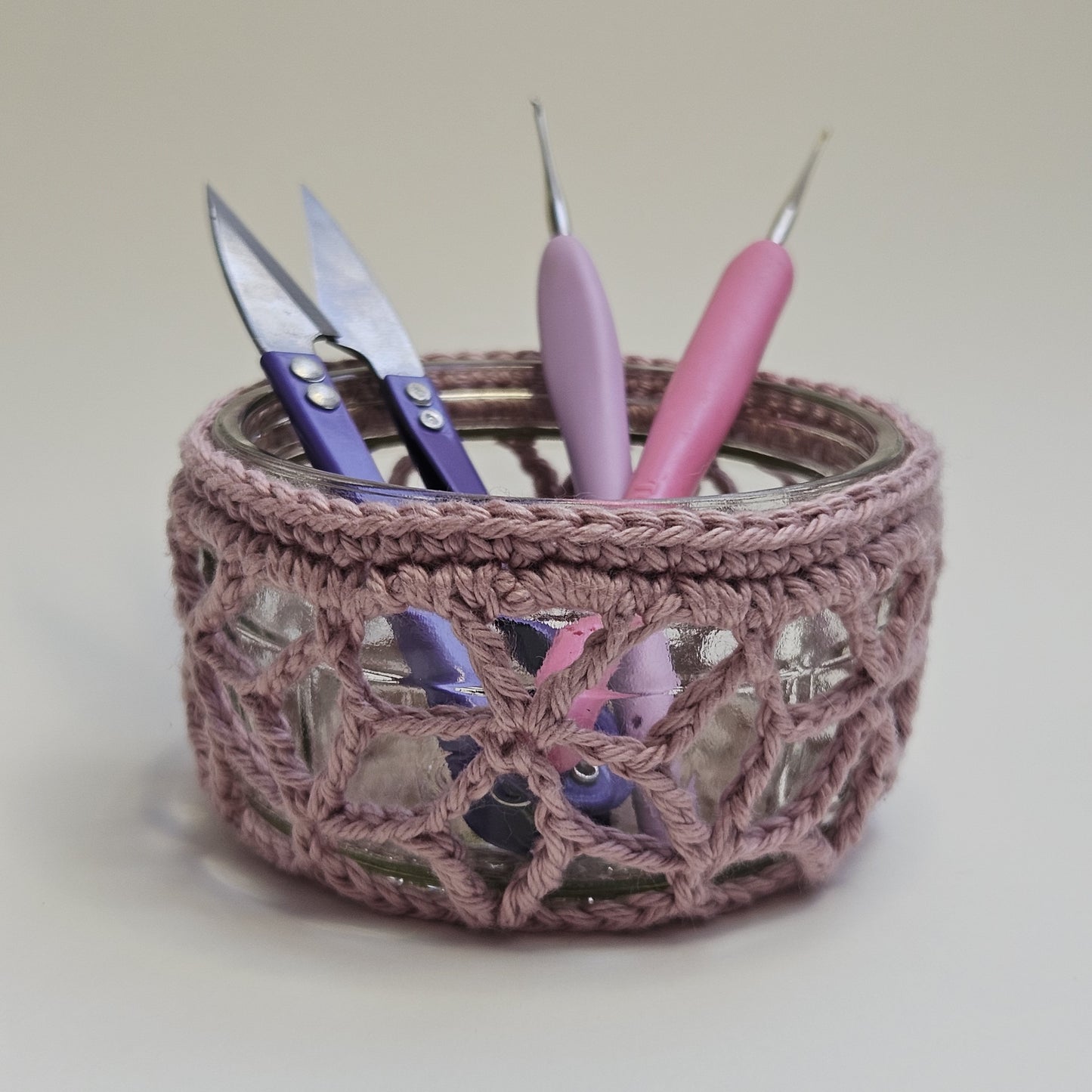 Crocheted yarn bowl with scissors and crochet hooks