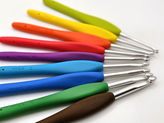 Set of Clover Amour Crochet Hooks arranged in a row, showcasing their colourful handles and smooth metal tips, displayed on a white surface.