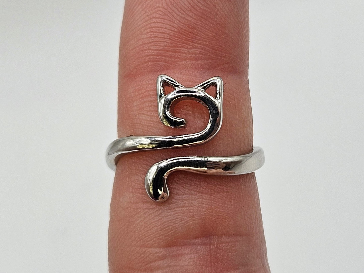 Silver cat-shaped crochet tension ring worn on a finger, shown against a plain white background to highlight its design.