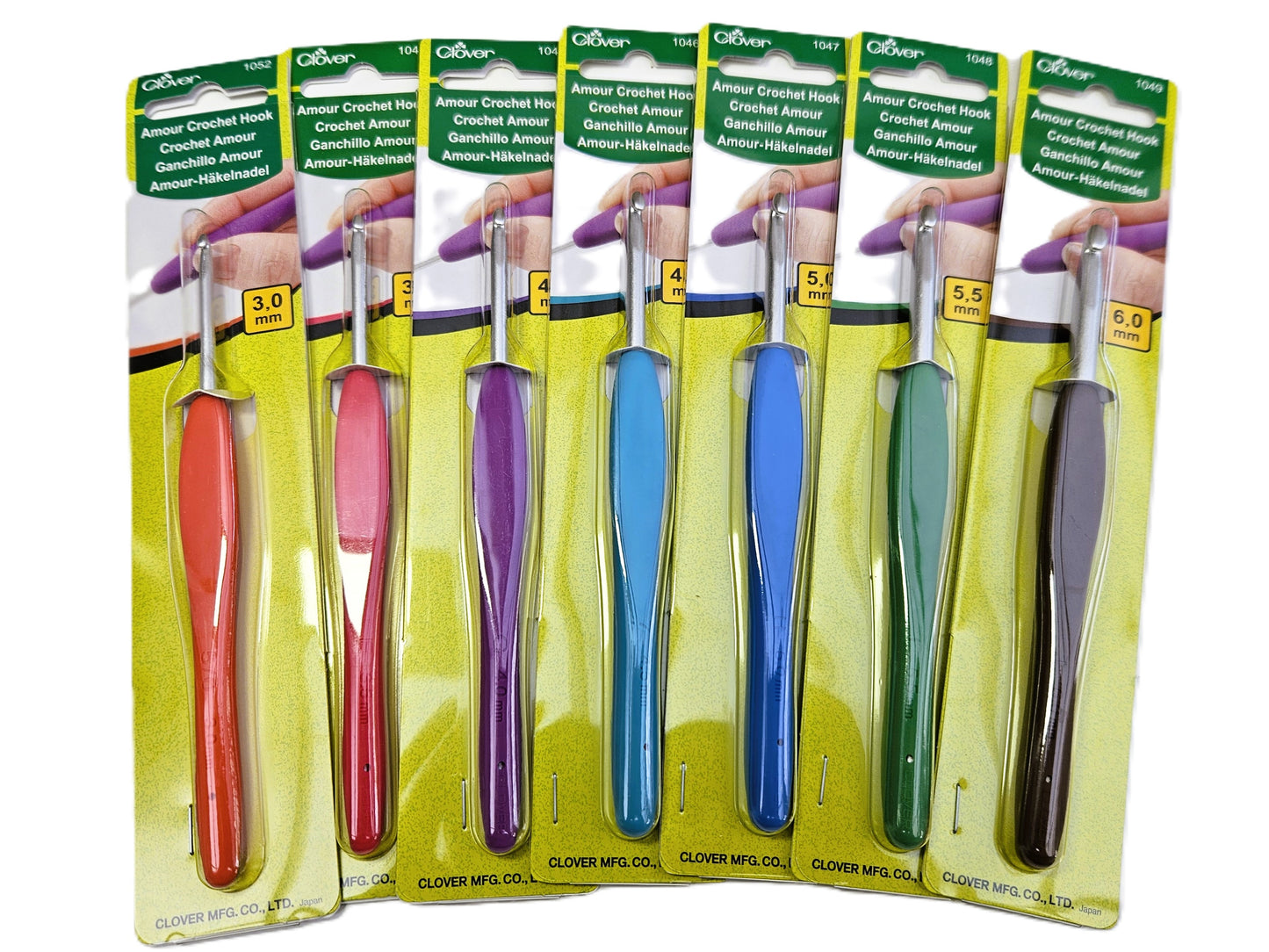 Set of individually packaged Clover Amour Crochet Hooks in various sizes and colours, arranged in a row on a white background.